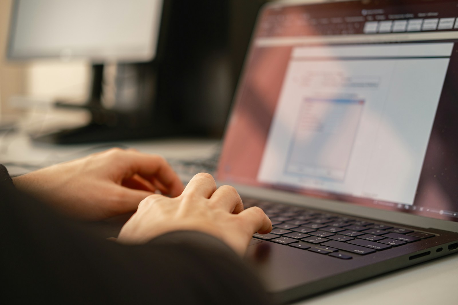 Close-up of hands typing on a laptop keyboard